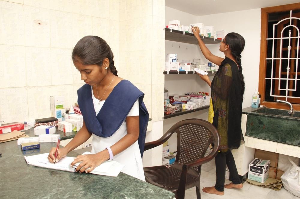Pharmacy staff dispensing and recording medication at Dhanyaa Medical Centre